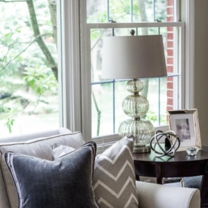 4871550109b6c78b_2663-w600-h900-b0-p0-- A closeup view of decorative pillows on a couch next to a decorative lamp.