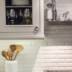 amberly-lane-kitchenware Custom kitchen with white brick wall, white cabinets and kitchenware.