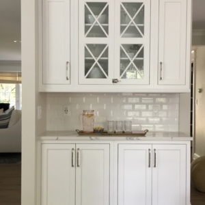 dining-room-hutch A white dining room hutch with dishes inside of it.