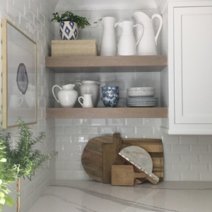 fairway-kitchen A kitchen with plates and cookwear sitting on shelves next to cupboards.