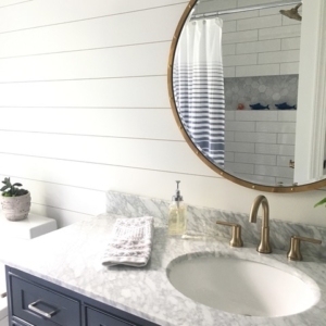 kids-bath A white bathroom counter with a decorative mirror above it on the wall.